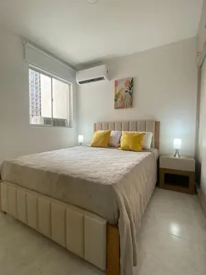 a bedroom with a large bed with yellow pillows at Cartagena Chic Full Apto in Cartagena de Indias