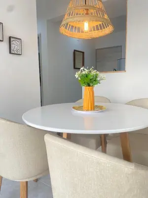 a white dining room table with a vase of flowers at Cartagena Chic Full Apto in Cartagena de Indias