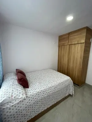 a bedroom with a bed and a wooden cabinet at Sky View Apartment en Barranquilla in Barranquilla