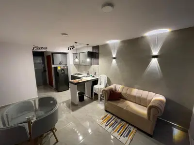 a living room with a couch and a kitchen at Sky View Apartment en Barranquilla in Barranquilla
