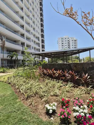 a garden in front of a building with flowers at Caribbean Refuge - Beach and Pool Access 10th Floor in Santa Marta