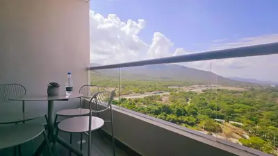 a balcony with a table and chairs and a view at Caribbean Refuge - Beach and Pool Access 10th Floor in Santa Marta