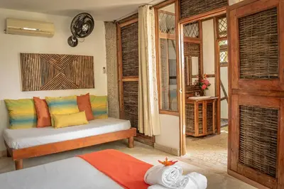 a living room with a couch with colorful pillows at Ekoparque Lunaforest in Guayepo