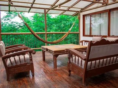 a porch with a hammock and a table and chairs at Ekoparque Lunaforest in Guayepo
