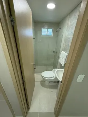 a bathroom with a toilet and a glass shower at Apto Acogedor Moderno y Familiar Excelente Ubicación norte Barranquilla in Barranquilla