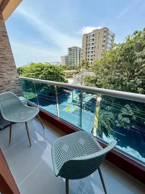 a balcony with two chairs and a swimming pool at Apto Acogedor Moderno y Familiar Excelente Ubicación norte Barranquilla in Barranquilla