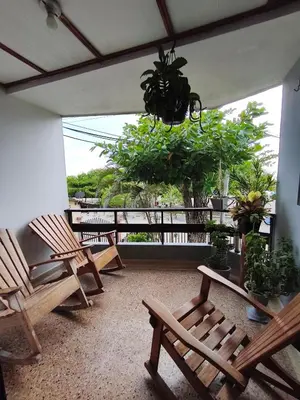 a porch with chairs and a chandelier and trees at Habitación con baño privado y aíre acondicionado frente al mar in Santiago
