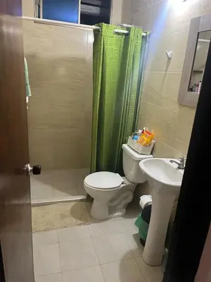 a bathroom with a toilet and a sink and a shower at Habitación con baño privado y aíre acondicionado frente al mar in Santiago