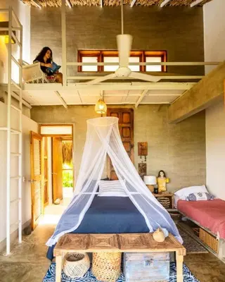 a bedroom with a bed with a mosquito net at En La Casa Del Mar in Moñitos