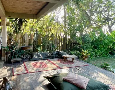 a patio with a couch and a table and trees at En La Casa Del Mar in Moñitos