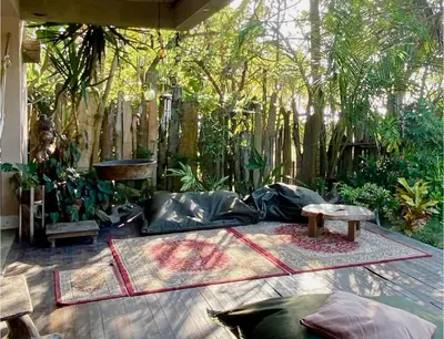a patio with a couch and a table and trees at En La Casa Del Mar in Moñitos