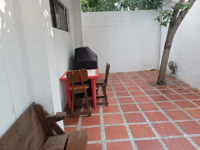 a red table and two chairs on a patio at La Trinidad in Santa Veronica