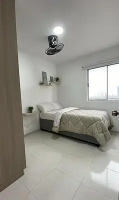 a white bedroom with a bed and a window at apartamento cerca de la playa in Cartagena de Indias