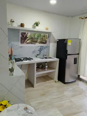 a small kitchen with a refrigerator and a sink at Kasa Soffi in Moñitos