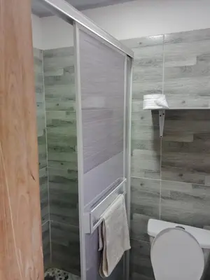 a bathroom with a toilet and a glass shower at Kasa Soffi in Moñitos