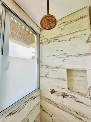 a bathroom with a stone wall and a window at Moderno apartamento en Playas del Francés