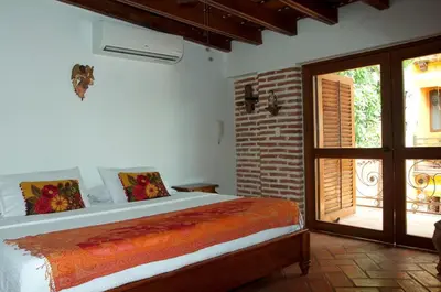 a bedroom with a bed and a door to a patio at Luxury Colonial Villa Old City Cartagena Rooftop Views Private Pool in Cartagena de Indias