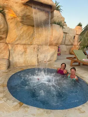 two children swimming in a pool with a waterfall at Aves de Laguna Beach