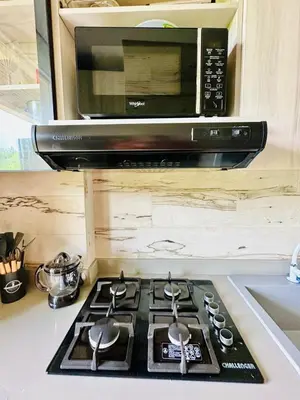 a stove top oven with a microwave above it at Aves de Laguna Beach
