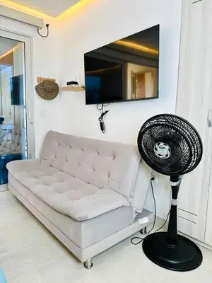 a living room with a white couch and a fan at Aves de Laguna Beach