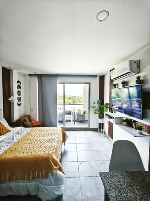 a bedroom with a bed and a flat screen tv at Modern suite steps from the sea in Santa Marta