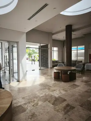 a lobby of a building with a table and chairs at Modern suite steps from the sea in Santa Marta