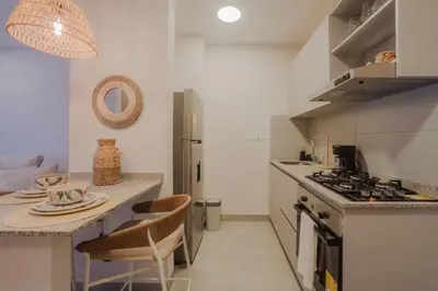 a kitchen with a counter and a table with chairs at Coastal Comfort Retreat Beach stay Near Airport in Santa Marta