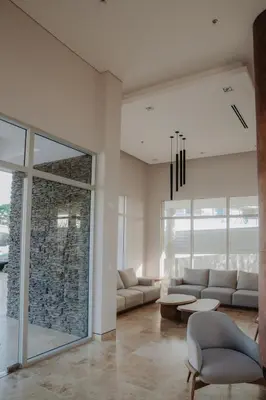 a living room with couches and a stone wall at Coastal Comfort Retreat Beach stay Near Airport in Santa Marta