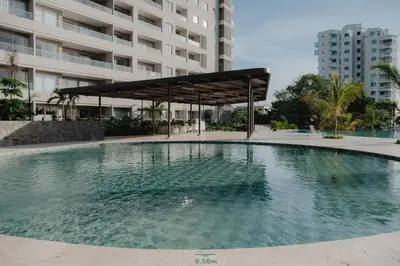 a large swimming pool in front of a building at Coastal Comfort Retreat Beach stay Near Airport in Santa Marta