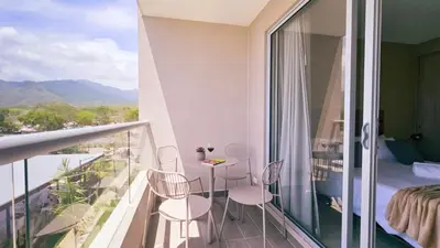 a balcony with a table and chairs and a bedroom at 1BD Luxe Shore & Balcony Sunrise Next to the Beach in Santa Marta