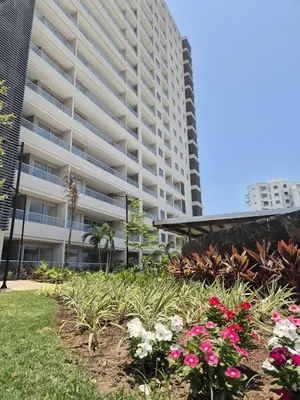 a large apartment building with flowers in front of it at 1BD Luxe Shore & Balcony Sunrise Next to the Beach in Santa Marta