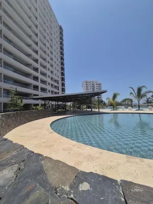 a swimming pool in front of a large building at 1BD Luxe Shore & Balcony Sunrise Next to the Beach in Santa Marta