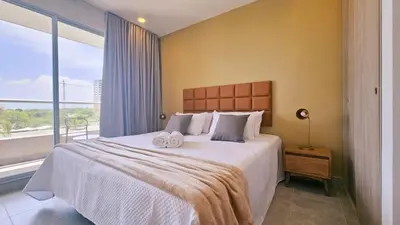 a bedroom with a large bed and a large window at 1BD Luxe Shore & Balcony Sunrise Next to the Beach in Santa Marta
