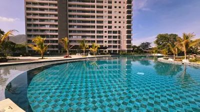 a large swimming pool in front of a tall building at 1BD Luxe Shore & Balcony Sunrise Next to the Beach in Santa Marta
