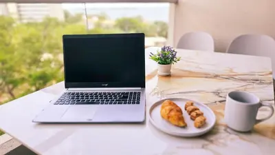 a laptop computer sitting on a table with a plate of food at 1BD Luxe Shore & Balcony Sunrise Next to the Beach in Santa Marta