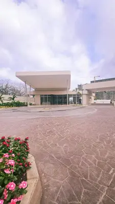 a large building with pink flowers in front of it at 1BD Luxe Shore & Balcony Sunrise Next to the Beach in Santa Marta