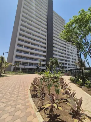 a large building with palm trees in front of it at 1BD Luxe Shore & Balcony Sunrise Next to the Beach in Santa Marta