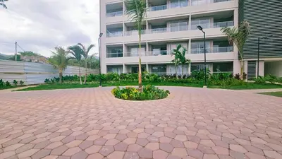 a courtyard in front of a building with a tree at Luxe Shore & Balcony Sunrise 1108 in Santa Marta