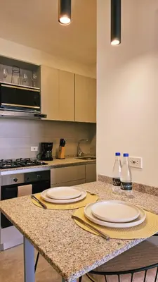 a kitchen with two plates and bottles on a counter at Luxe Shore & Balcony Sunrise 1108 in Santa Marta
