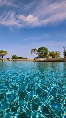 a large pool of blue water with trees in the background at Luxe Shore & Balcony Sunrise 1108 in Santa Marta