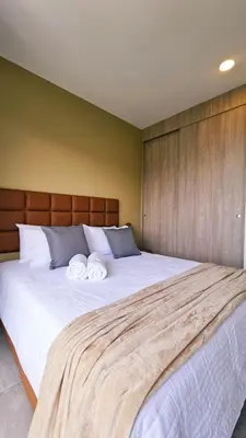a bedroom with a large bed with two towels on it at Seaside Retreat Beach Entrance 20th Floor in Santa Marta