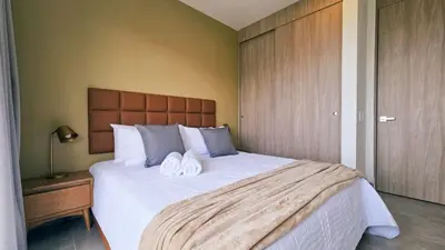a bedroom with a large bed with two towels on it at Seaside Retreat Beach Entrance 20th Floor in Santa Marta
