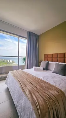 a bedroom with a large bed and a large window at Seaside Retreat Beach Entrance 20th Floor in Santa Marta