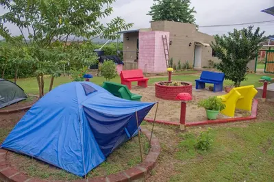 a blue tent in a garden with colorful furniture at Hostal Cultural El Telar in San Jacinto