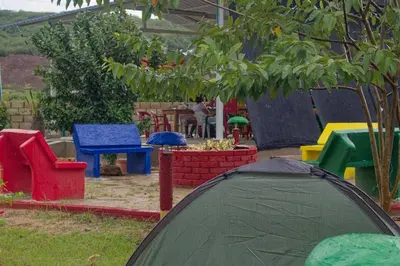 a garden with colorful chairs and a tent at Hostal Cultural El Telar in San Jacinto