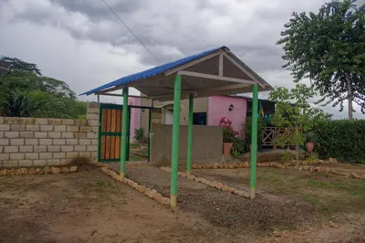 a small building with a blue roof and green poles at Hostal Cultural El Telar in San Jacinto