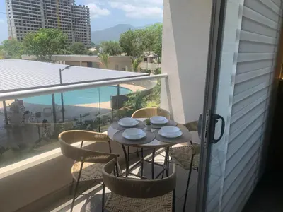 a balcony with a table with bowls and plates on it at Apartamento Playa y piscina, Santa Marta in Santa Marta