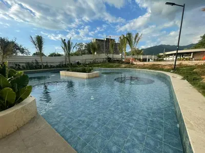 a swimming pool with blue water in a resort at Apartamento Playa y piscina, Santa Marta in Santa Marta