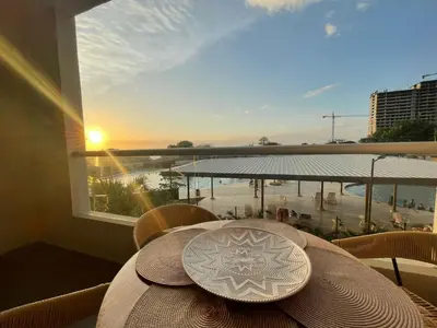 a table with a hat on a balcony with a view of a beach at Apartamento Playa y piscina, Santa Marta in Santa Marta