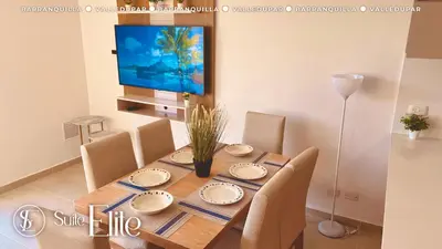 a dining room with a table with chairs and a television at Barranquilla Super Suite Elite in Barranquilla